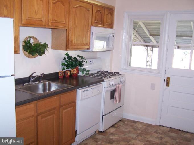 1558 Winford Road Baltimore, MD 21239 - Photo 3 of 9 a kitchen with stainless steel appliances granite countertop a sink a stove and a granite counter tops with a window
