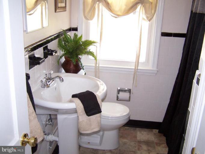 1558 Winford Road Baltimore, MD 21239 - Photo 8 of 9 a bathroom with a toilet sink and a mirror