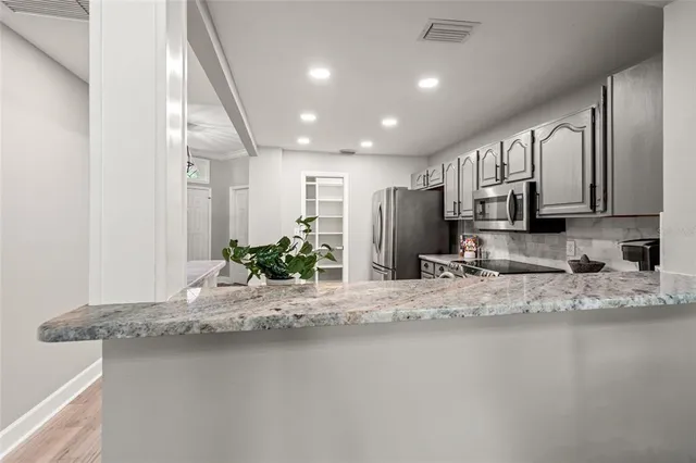 a kitchen with stainless steel appliances granite countertop a sink refrigerator and microwave