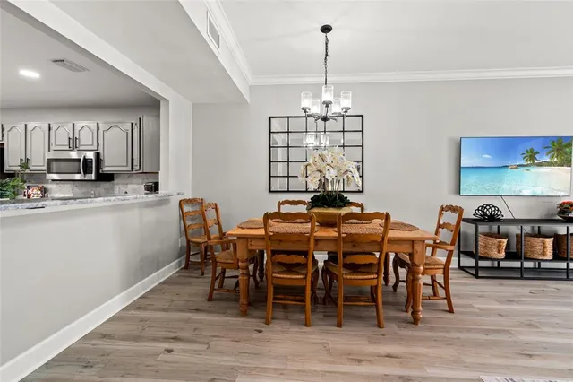 a view of a dining room with furniture wooden floor and chandelier