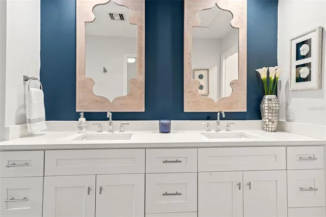 a bathroom with a double vanity sink mirror and