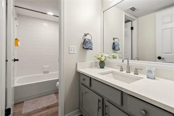 a bathroom with a granite countertop sink and a mirror