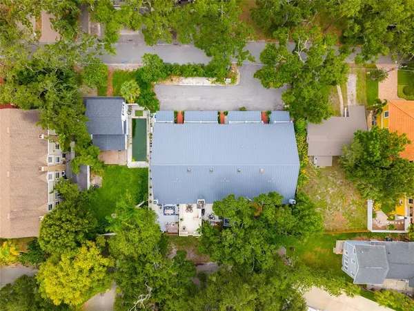 an aerial view of residential houses with outdoor space and trees