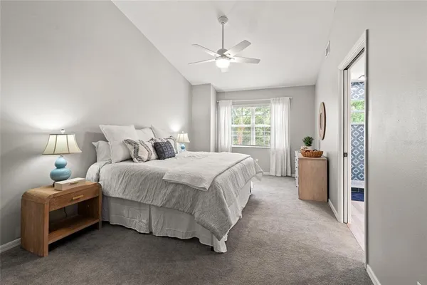 a spacious bedroom with a bed and a chandelier