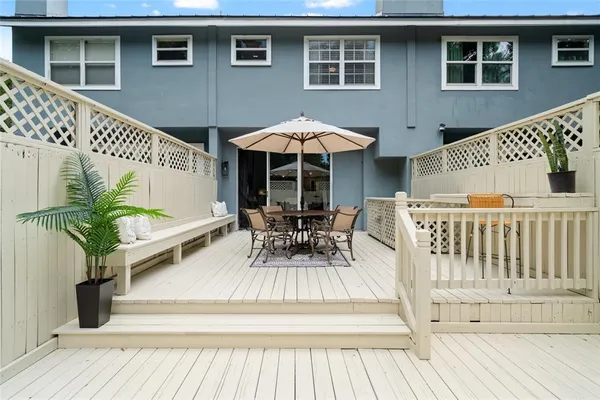a view of house with deck outdoor seating and wooden floor