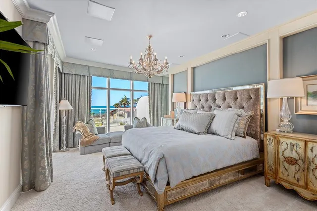 a bedroom with a large bed and a chandelier