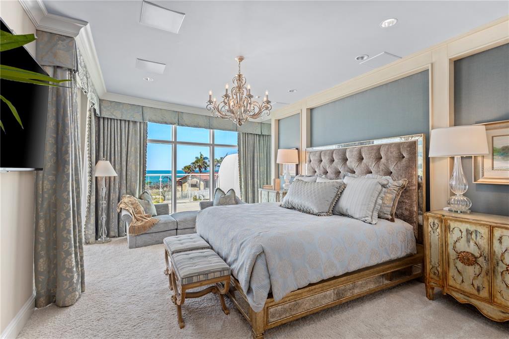 2251 Gulf Of Mexico Drive, Unit 203 Longboat Key, FL 34228 - Photo 2 of 21 a bedroom with a large bed and a chandelier