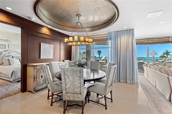 a dining room with furniture a chandelier and wooden floor