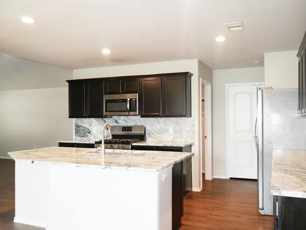 a kitchen with stainless steel appliances a microwave a sink and a refrigerator