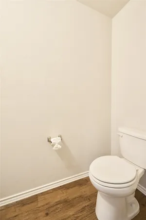 a white toilet sitting next to a white wall
