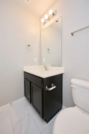a bathroom with a sink vanity and a toilet