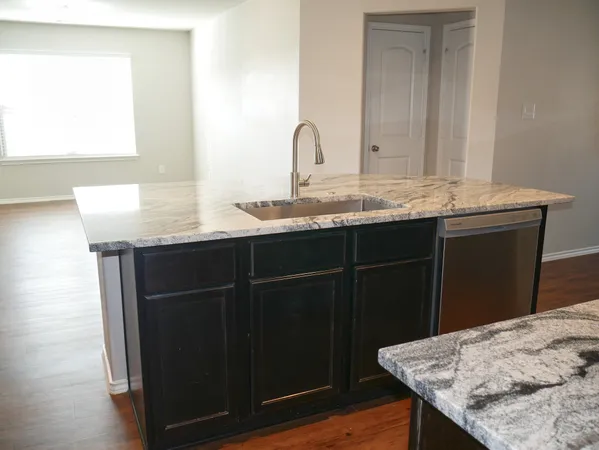 a bathroom with a granite countertop sink a mirror and a wooden cabinets