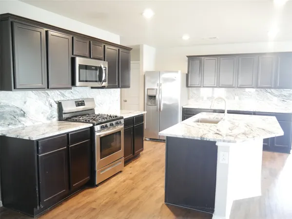 a kitchen with a sink and steel appliances
