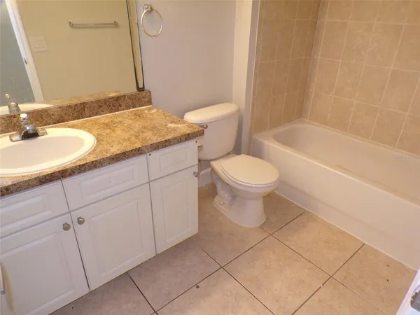 a bathroom with a granite countertop sink a toilet and a mirror