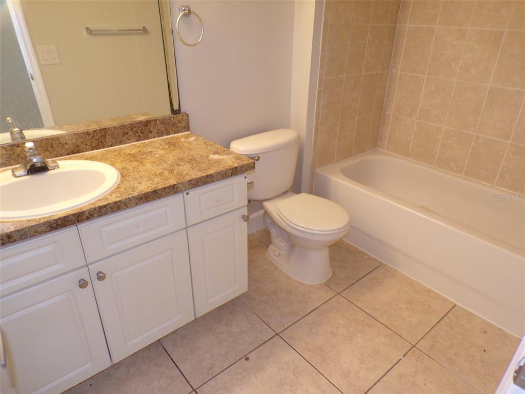 4518 Commander Drive, Unit 1921 Orlando, FL 32822 - Photo 12 of 18 a bathroom with a granite countertop sink a toilet and a mirror