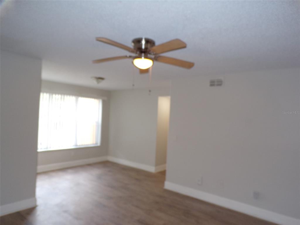 4518 Commander Drive, Unit 1921 Orlando, FL 32822 - Photo 18 of 18 wooden floor in an empty room with a window