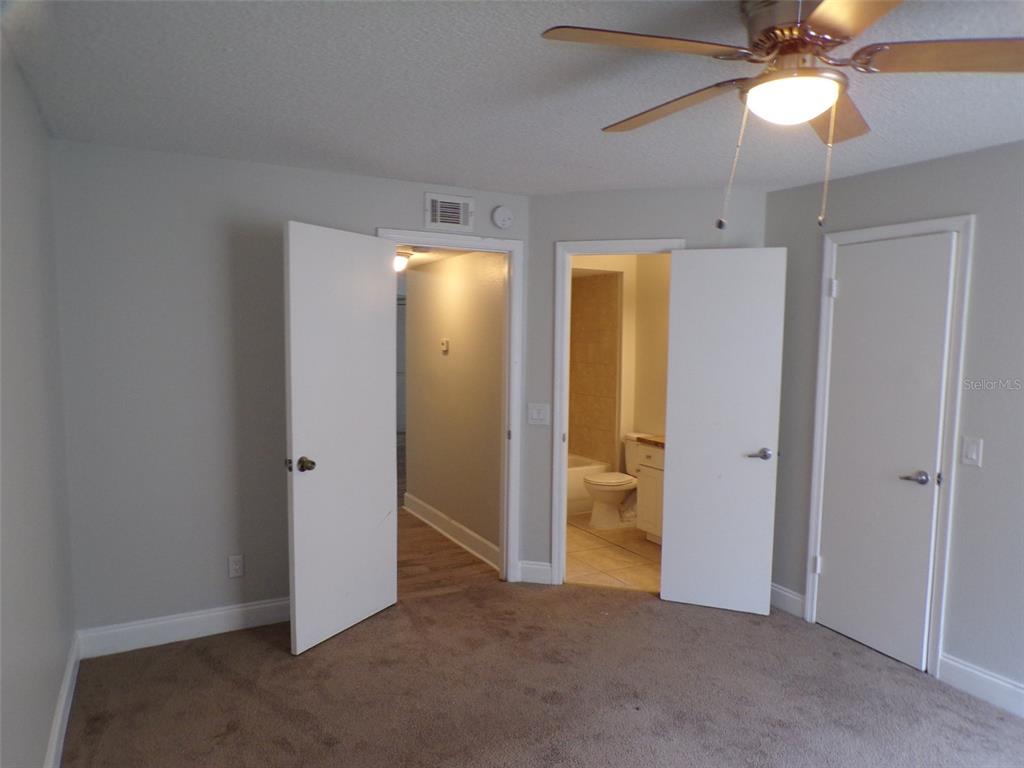 4518 Commander Drive, Unit 1921 Orlando, FL 32822 - Photo 5 of 18 an empty room with closet and a chandelier fan