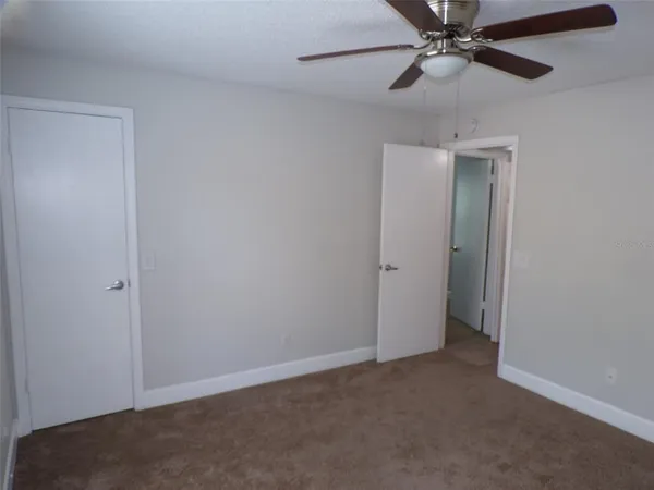 an empty room with a fan and a fan