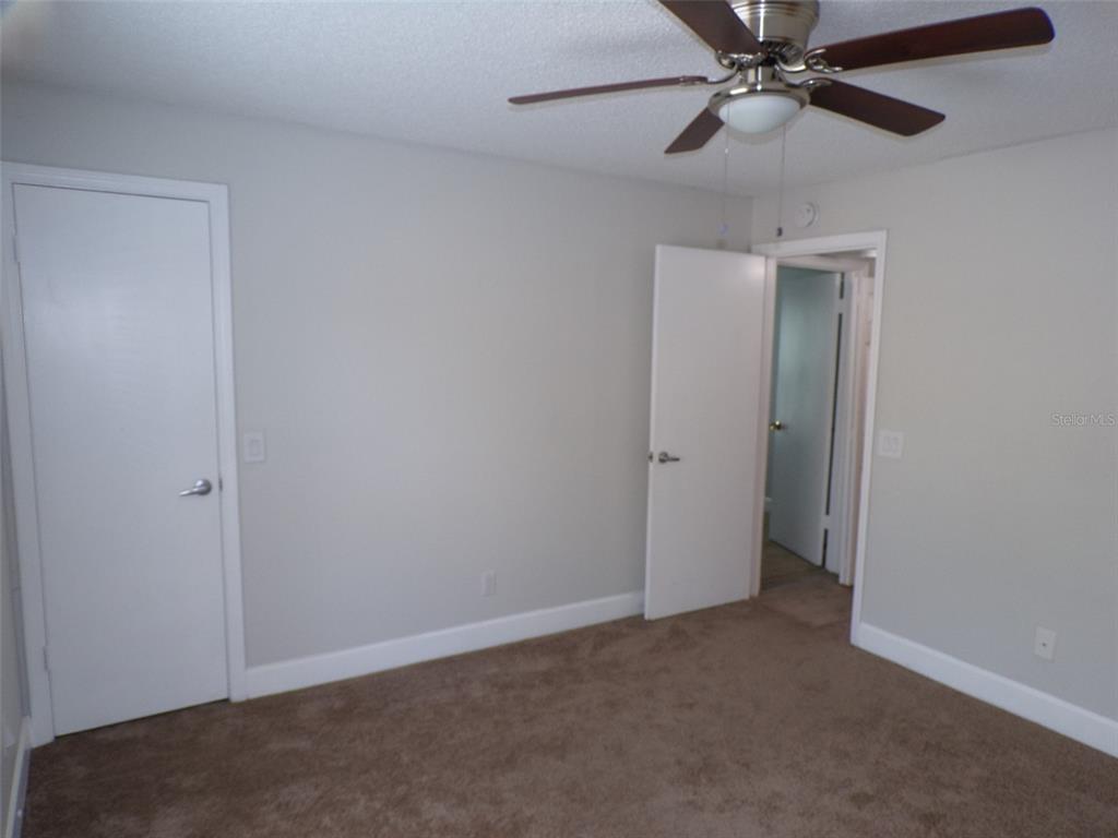4518 Commander Drive, Unit 1921 Orlando, FL 32822 - Photo 9 of 18 an empty room with a fan and a fan