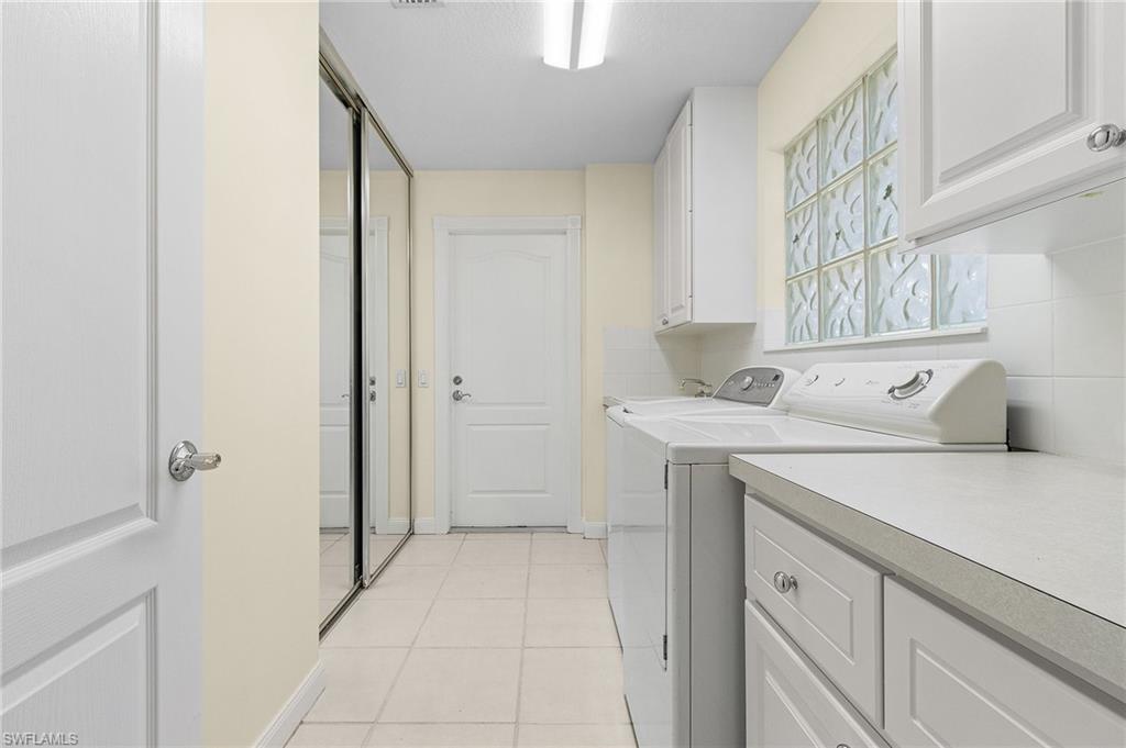 4187 St George Lane Naples, FL 34119 - Photo 12 of 27 Laundry room featuring cabinets, separate washer and dryer, and light tile patterned floors