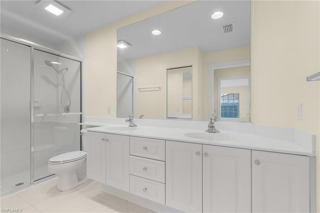 4187 St George Lane Naples, FL 34119 - Photo 19 of 27 Bathroom with tile patterned floors, vanity, toilet, and walk in shower