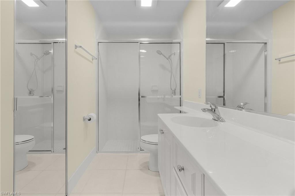 4187 St George Lane Naples, FL 34119 - Photo 20 of 27 Bathroom featuring tile patterned floors, vanity, walk in shower, and toilet