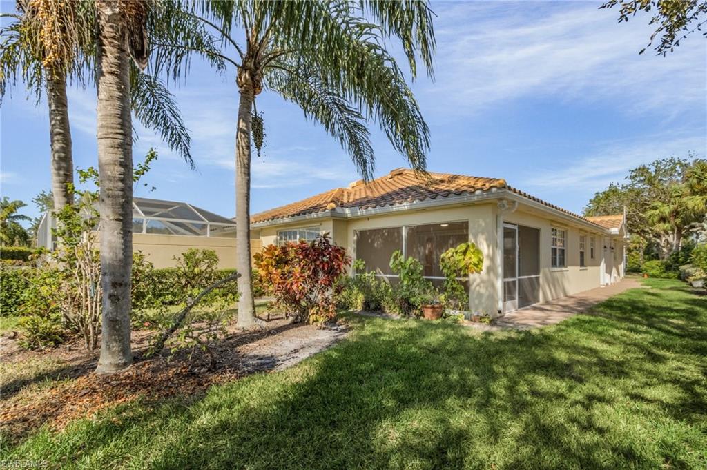 4187 St George Lane Naples, FL 34119 - Photo 23 of 27 Rear view of property with a yard