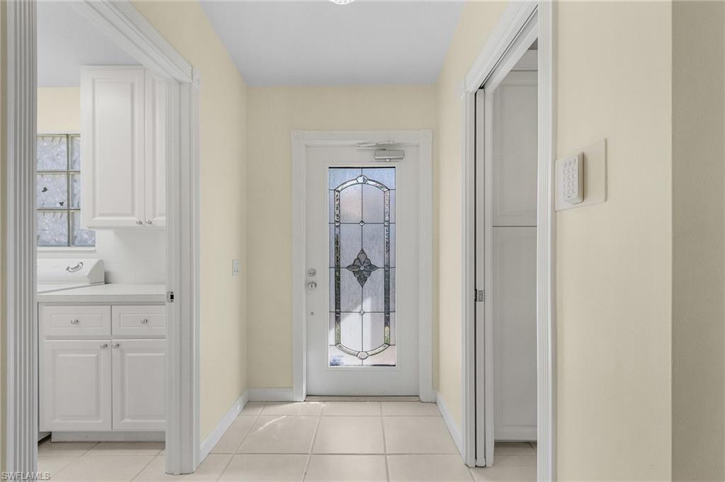 4187 St George Lane Naples, FL 34119 - Photo 4 of 27 Doorway to outside featuring light tile patterned floors