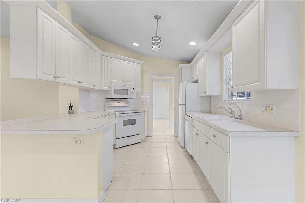 4187 St George Lane Naples, FL 34119 - Photo 5 of 27 Kitchen featuring white cabinets, decorative light fixtures, white appliances, and sink