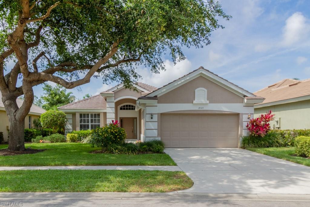 1869 Pondside Lane Naples, FL 34109 - Photo 1 of 35 a front view of a house with a garden