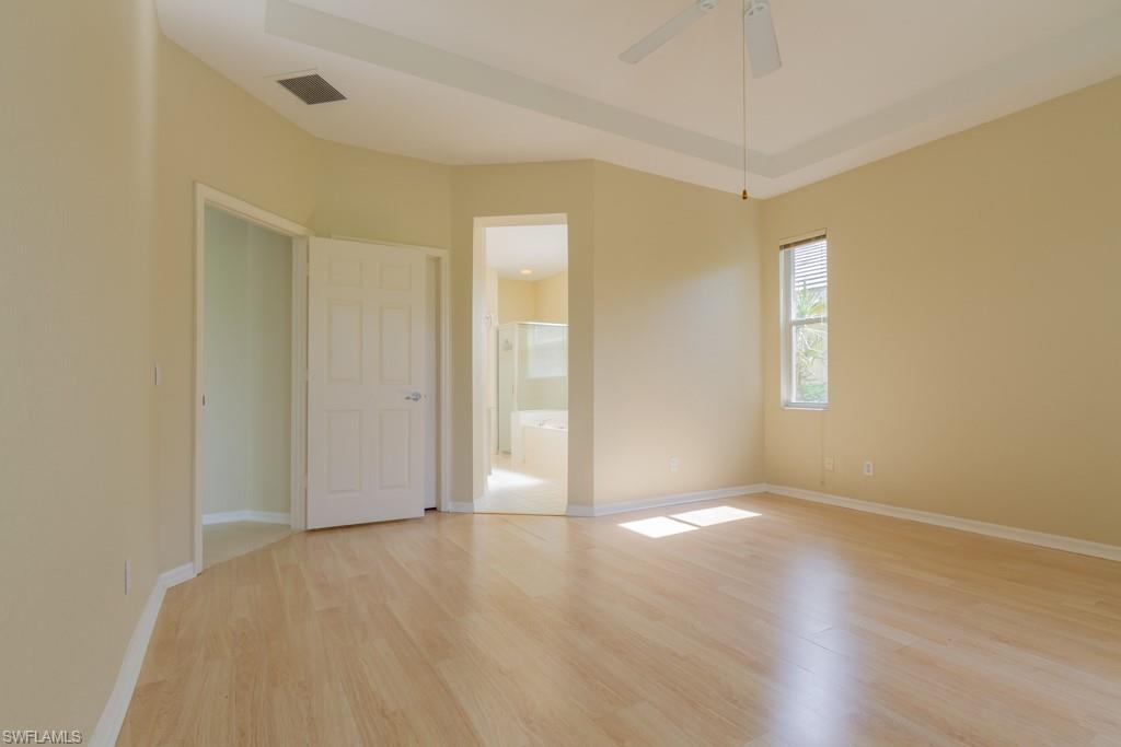 1869 Pondside Lane Naples, FL 34109 - Photo 11 of 35 an empty room with wooden floor and windows