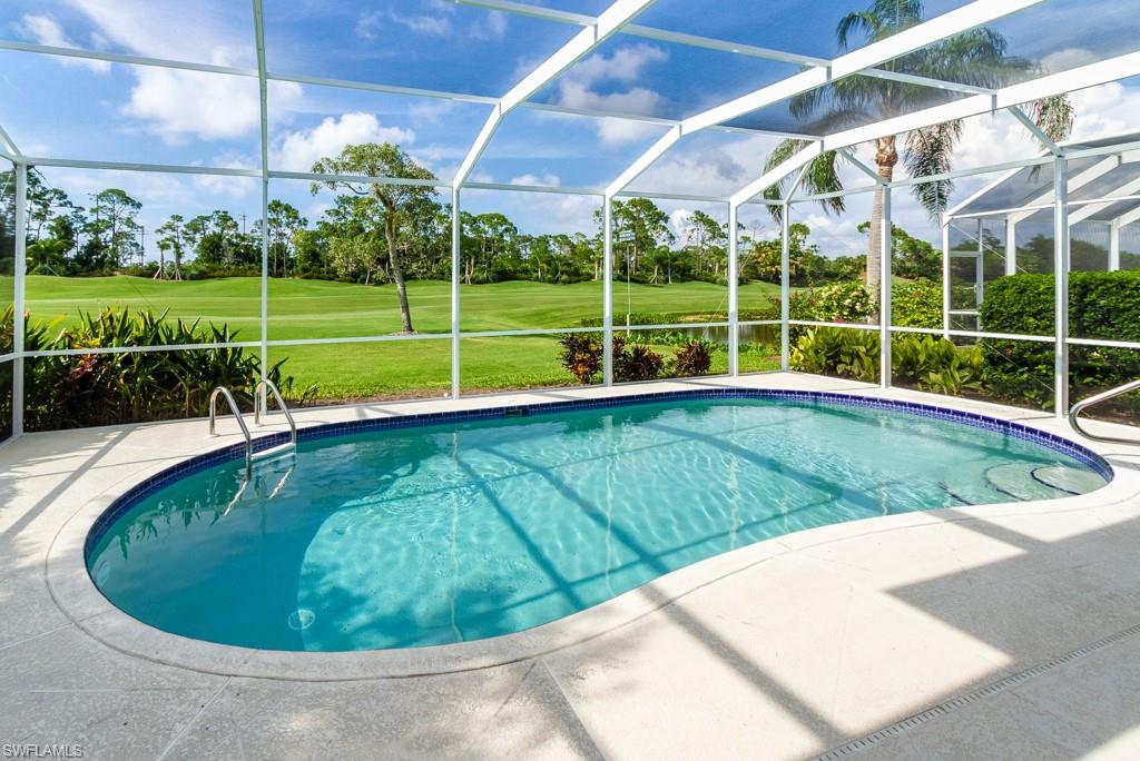 1869 Pondside Lane Naples, FL 34109 - Photo 2 of 35 a view of a swimming pool with a yard in front of it