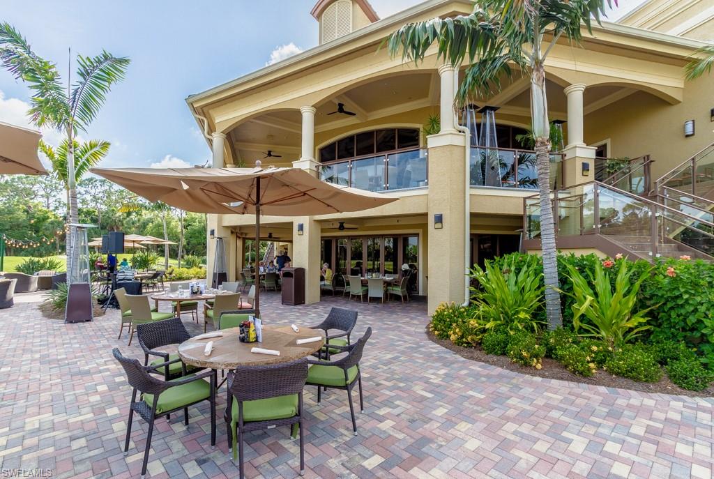 1869 Pondside Lane Naples, FL 34109 - Photo 30 of 35 a view of a patio with table and chairs under an umbrella