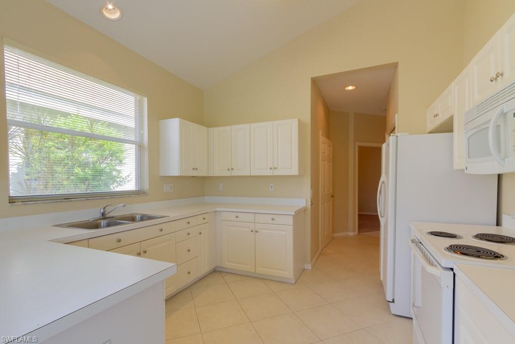 1869 Pondside Lane Naples, FL 34109 - Photo 7 of 35 a kitchen with a sink cabinets appliances and a window