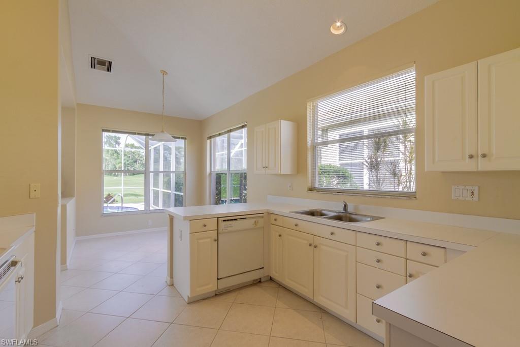 1869 Pondside Lane Naples, FL 34109 - Photo 8 of 35 a kitchen with a sink stove and cabinets