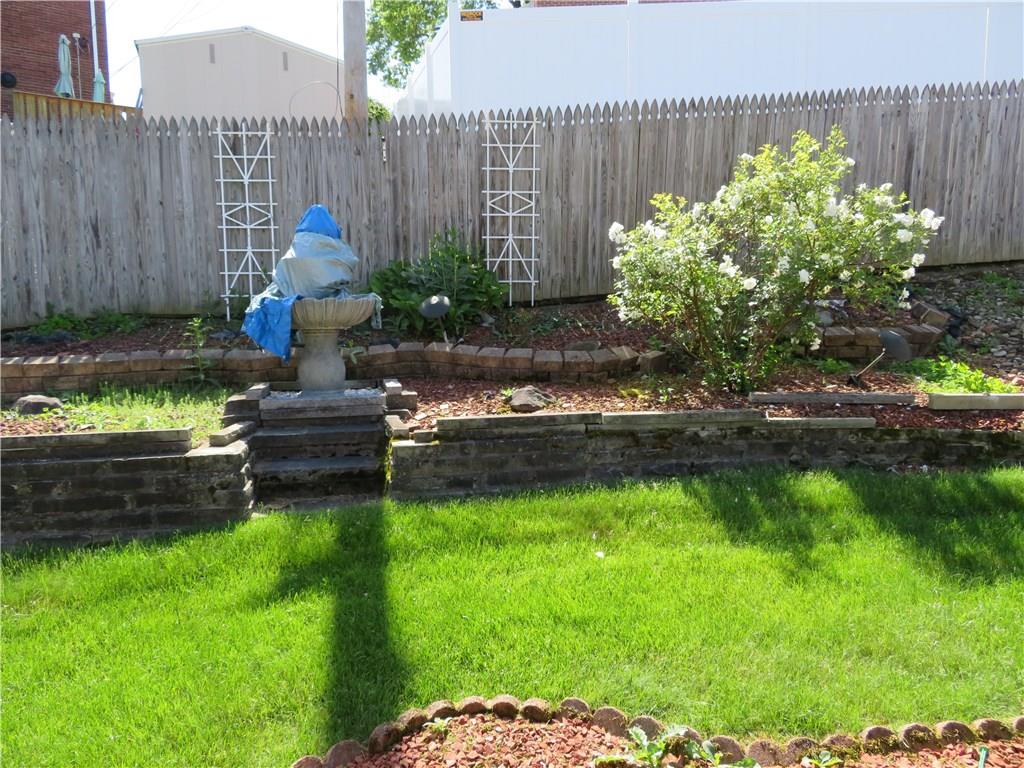 3701 Wayne Road Munhall, PA 15120 - Photo 19 of 20 private fenced back yard with water fountain and stone retaining walls.