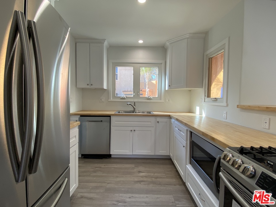 4247 9th Avenue Los Angeles, CA 90008 - Photo 23 of 45 a kitchen with stainless steel appliances granite countertop a refrigerator sink and stove