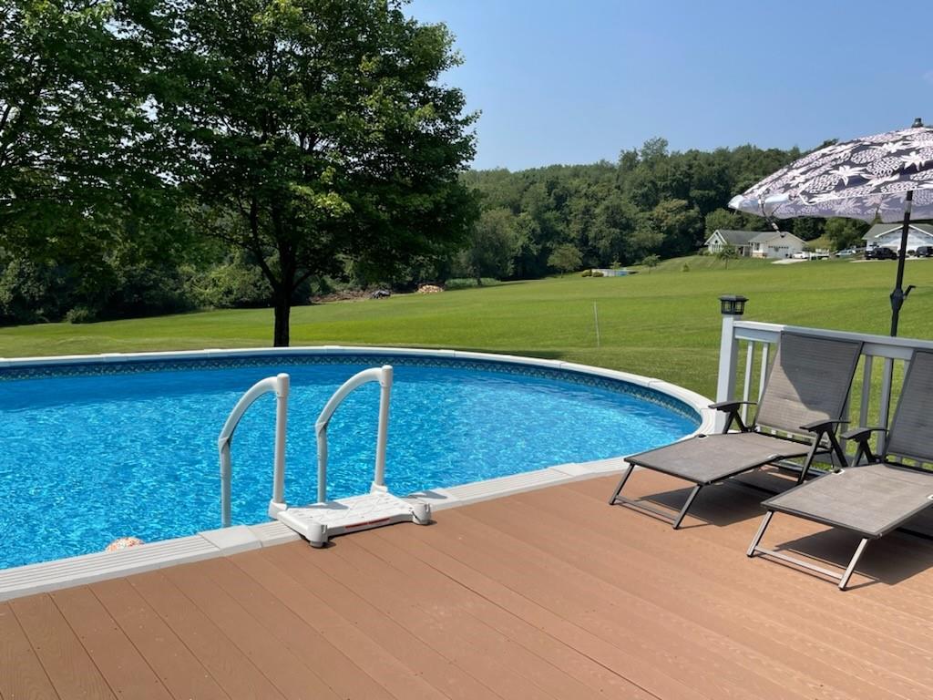 2149 Kingview Road Scottdale, PA 15683 - Photo 30 of 31 a view of a swimming pool with lawn chairs under an umbrella