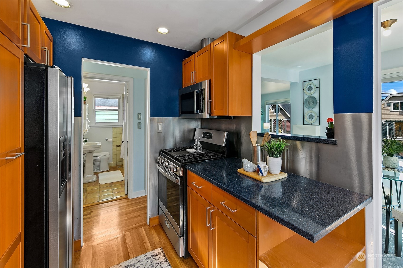 4415 Eastern Avenue North Seattle, WA 98103 - Photo 11 of 27 a kitchen with stainless steel appliances granite countertop a refrigerator a stove and a sink with wooden floor