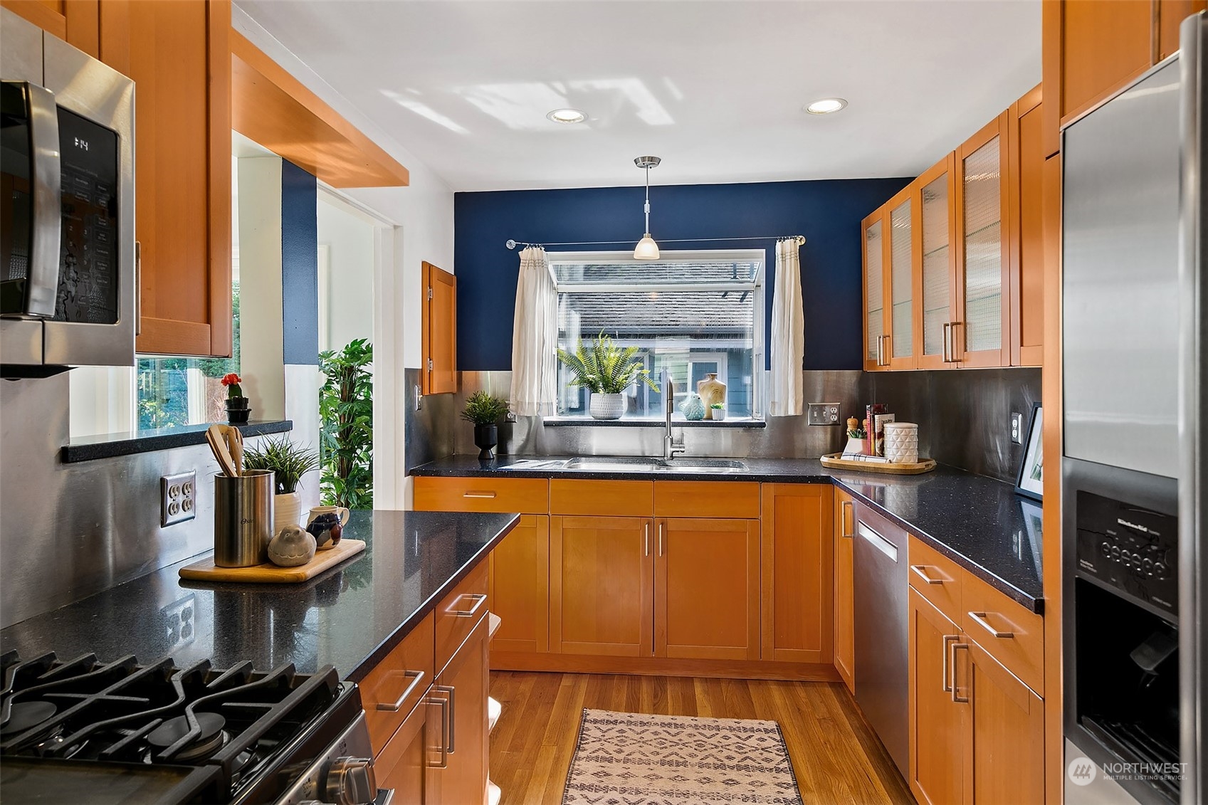 4415 Eastern Avenue North Seattle, WA 98103 - Photo 10 of 27 a kitchen with stainless steel appliances a sink stove and cabinets
