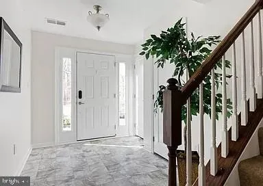 a view of an entryway with wooden floor and stairs