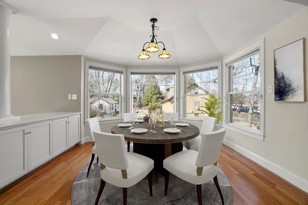 a view of a dining room with furniture a chandelier and wooden floor