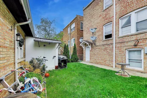 a view of back yard of the house with outdoor seating