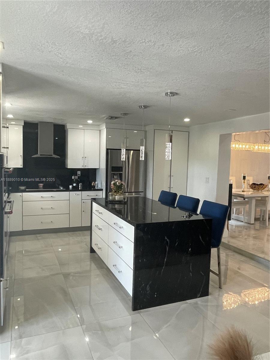 390 East 53rd Street Hialeah, FL 33013 - Photo 8 of 21 a large kitchen with kitchen island a sink a counter top space and stainless steel appliances