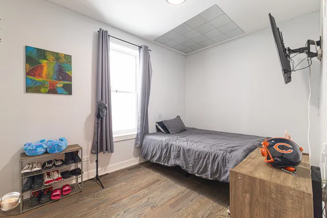 a bedroom with a bed and wooden floor