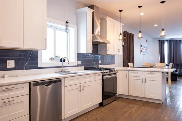 a kitchen with white cabinets and sink