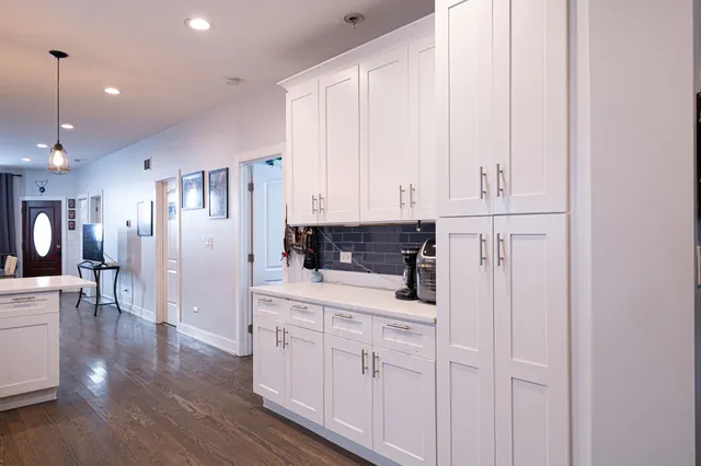 a kitchen with white cabinets and sink