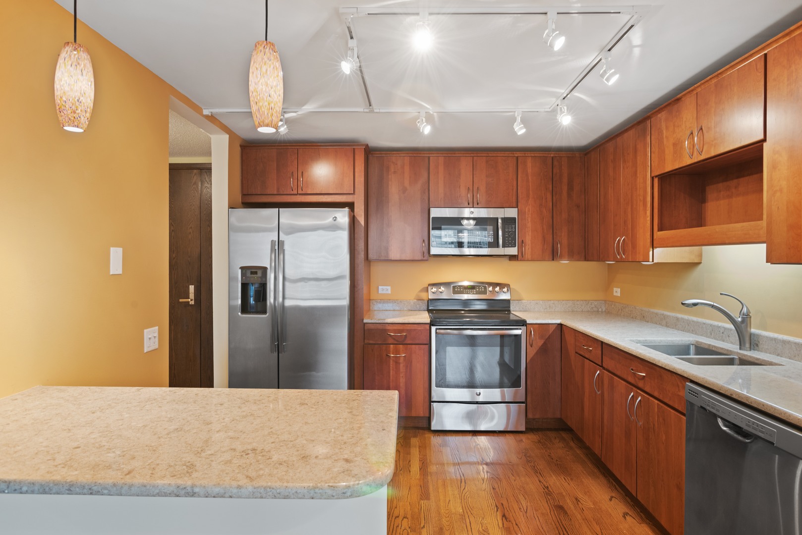 360 East Randolph Street, Unit 707 Chicago, IL 60601 - Photo 7 of 20 a kitchen with stainless steel appliances granite countertop a refrigerator a sink dishwasher a stove with wooden cabinets and floor