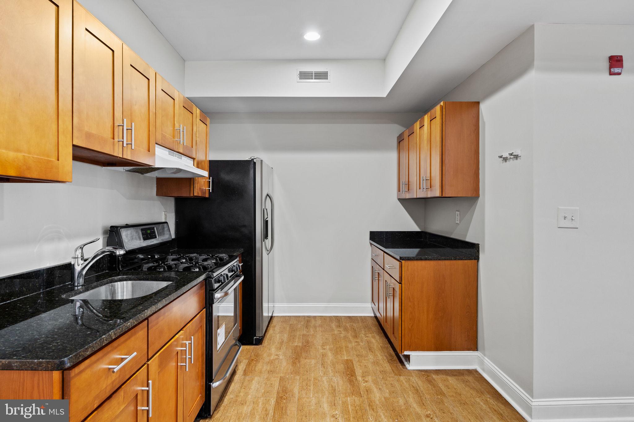 426 South 44th Street, Unit 2 Philadelphia, PA 19104 - Photo 16 of 31 a kitchen with stainless steel appliances granite countertop a stove a sink and a refrigerator