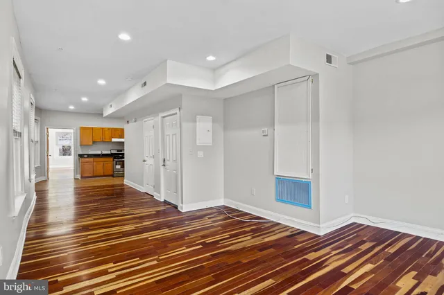 a view of empty room with wooden floor